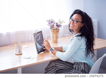 Joyful smiling woman sitting at the table 24874275