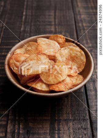 Bowl with potato crisps chips on wooden board 24874996