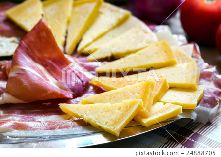 Prosciutto with tomatoes and some cheese. 24888705