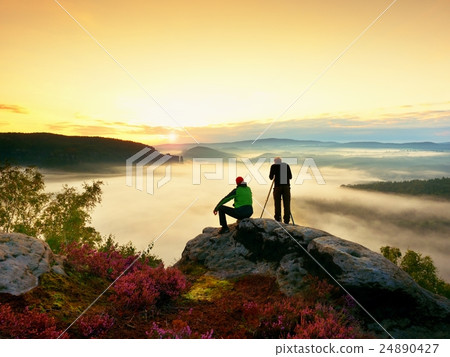 Hiker and photo enthusiast with tripod on cliff Hiker and photo enthusiast with tripod on cliff 24890427