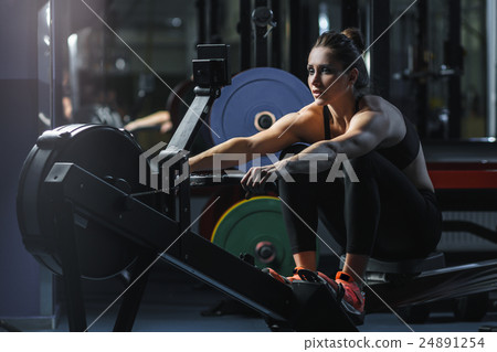 woman CrossFit trainer do workout on indoor rower woman CrossFit trainer do workout on indoor rower 24891254