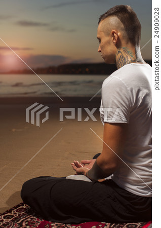 Yoga man with tattoos meditating in lotus pose Yoga man with tattoos meditating in lotus pose 24909028