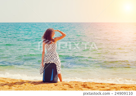 Young happy girl siting on the traveling bag on th 24909110