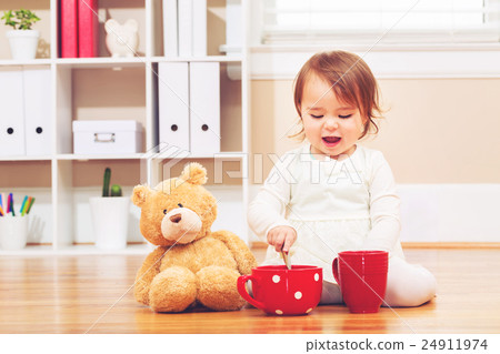 A girl playing with a stuffed bear A girl playing with a stuffed bear 24911974
