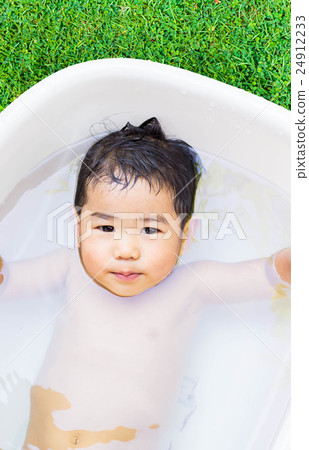 cute baby boy taking water procedures in summer garden 24912233