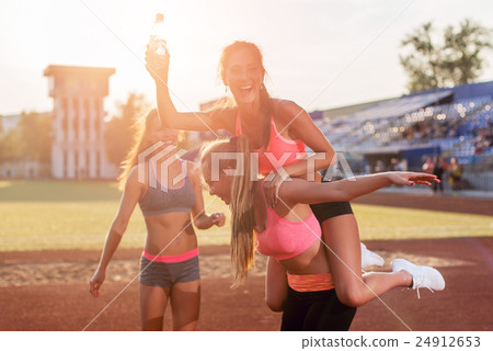 Group fit women giving piggyback ride Happy young 24912653