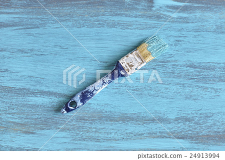 Paintbrush with blue paint on a wooden board. Paintbrush with blue paint on a wooden board. 24913994