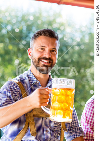 Man in traditional bavarian clothes holding mug of Man in traditional bavarian clothes holding mug of 24914366