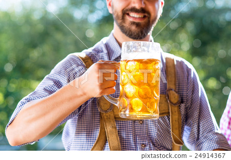 Man in traditional bavarian clothes holding mug of Man in traditional bavarian clothes holding mug of 24914367