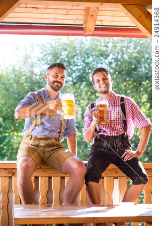 Men in traditional bavarian clothes holding mugs Men in traditional bavarian clothes holding mugs 24914368