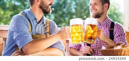 Men in traditional bavarian clothes holding mugs Men in traditional bavarian clothes holding mugs 24914369
