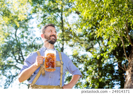 Man in traditional bavarian clothes holding mug of Man in traditional bavarian clothes holding mug of 24914371