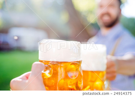 Man in traditional bavarian clothes holding mug of Man in traditional bavarian clothes holding mug of 24914375