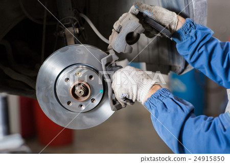 Brand new brake disc on car in a garage. Auto 24915850