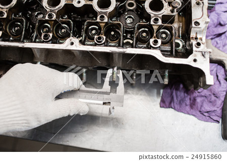 Mechanic, using a calipher, to check the thickness 24915860