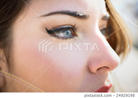 Close-up of young woman's blue eyes with long eyelashes 24929198