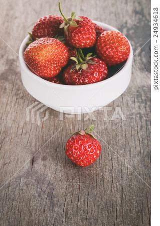 fresh strawberries in bowl on wood table 24934618
