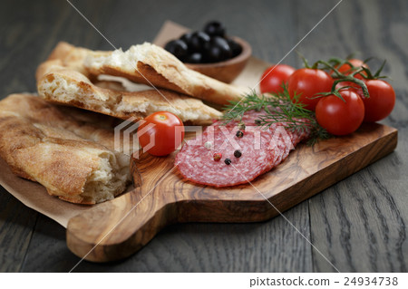 Antipasti with salami, olives, tomatoes and bread 24934738