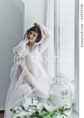 Portrait of a girl in a negligee on of the window 24934746