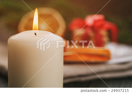 burning candle in front of christmas table,  24937215