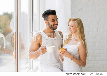 Young Beautiful Couple Stand Near Big Window Young Beautiful Couple Stand Near Big Window 24948360