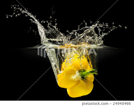 Yellow bell pepper falling in water on black Yellow bell pepper falling in water on black 24948466