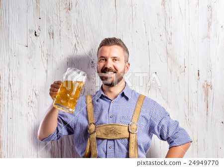 Man in traditional bavarian clothes holding mug of 24949770