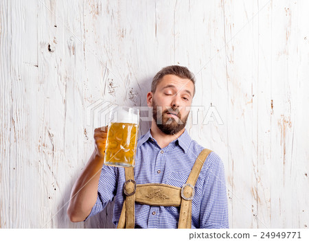 Drunk man in traditional bavarian clothes holding 24949771