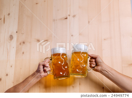 Two unrecognizable men clinking with beer mugs Two unrecognizable men clinking with beer mugs 24949774