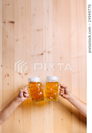 Two unrecognizable men clinking with beer mugs Two unrecognizable men clinking with beer mugs 24949776