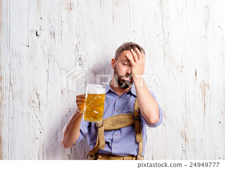 Drunk man in traditional bavarian clothes holding Drunk man in traditional bavarian clothes holding 24949777