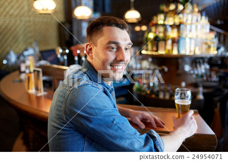 happy man drinking draft beer at bar or pub happy man drinking draft beer at bar or pub 24954071