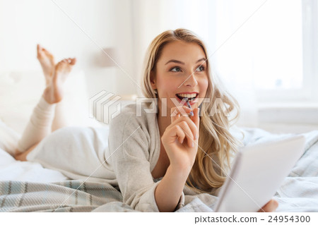 happy young woman with notebook in bed at home 24954300
