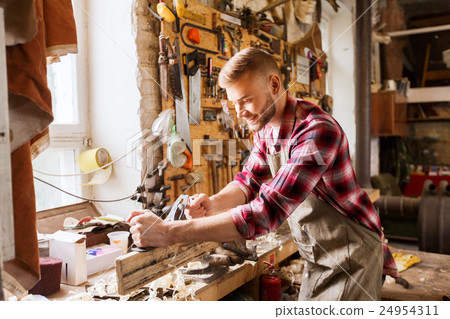 carpenter working with plane and wood at workshop carpenter working with plane and wood at workshop 24954311