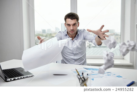 angry businessman throwing papers in office 24955282