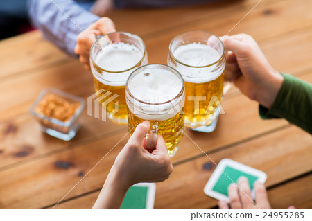 close up of hands with beer mugs at bar or pub close up of hands with beer mugs at bar or pub 24955285