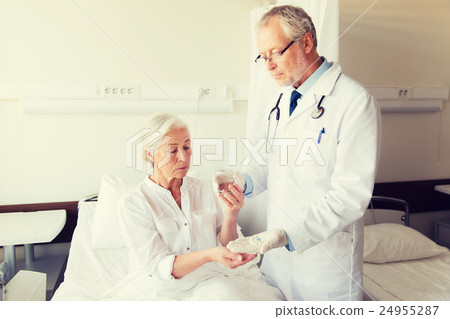 doctor giving medicine to senior woman at hospital 24955287