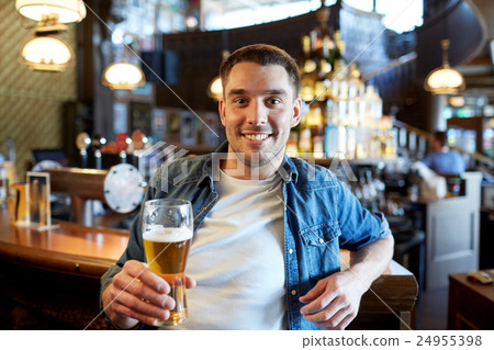 happy man drinking draft beer at bar or pub 24955398
