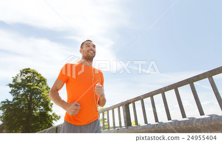 happy man with earphones running outdoors happy man with earphones running outdoors 24955404