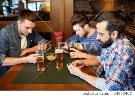 men with smartphones drinking beer at bar or pub men with smartphones drinking beer at bar or pub 24955407