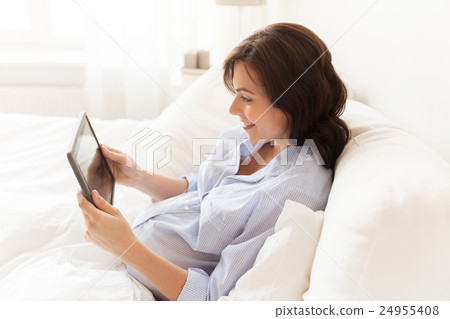 happy pregnant woman with tablet pc at home happy pregnant woman with tablet pc at home 24955408