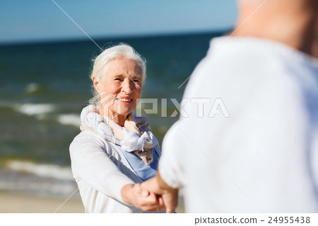 happy senior couple holding hands on summer beach happy senior couple holding hands on summer beach 24955438