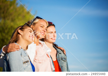 happy women or teenage girls hugging outdoors happy women or teenage girls hugging outdoors 24955440