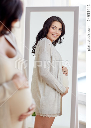 happy pregnant woman looking to mirror at home 24955441