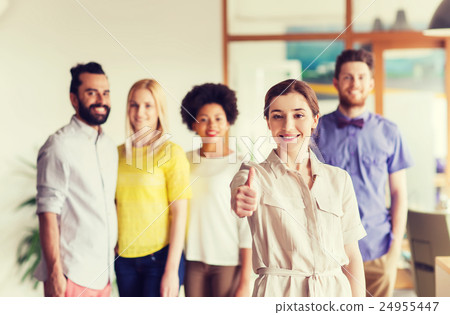 woman showing thumbs up over creative office team 24955447