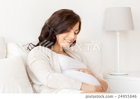 happy pregnant woman lying on bed at home 24955846