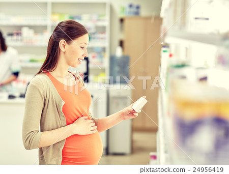 happy pregnant woman with medication at pharmacy 24956419