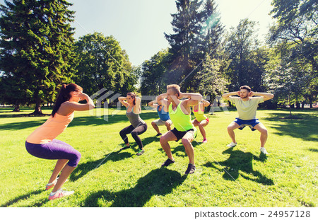 group of happy friends exercising outdoors 24957128