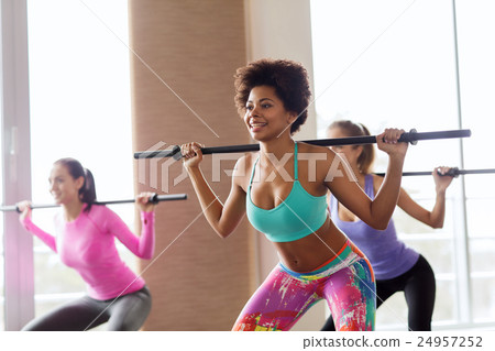 group of people exercising with bars in gym 24957252