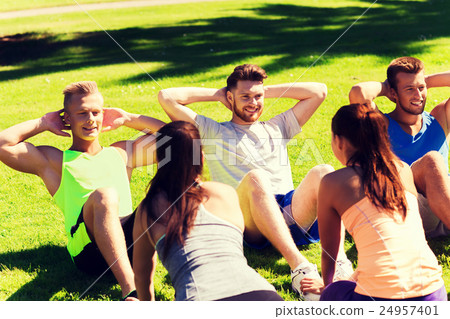 group of friends or sportsmen exercising outdoors 24957401
